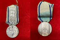 VENTENNIO FASCISTA. Vittorio Emanuele III (1900-1943). Medaglia d'onore per le madri di famiglie numerose, nastrino originale con 6 fiocchi. SPL