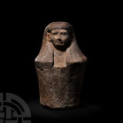 Egyptian Limestone Dummy Canopic Jar. Late Dynastic Period, 404-323 B.C. A limestone dummy canopic jar with tapering cylindrical body, upper body carv...