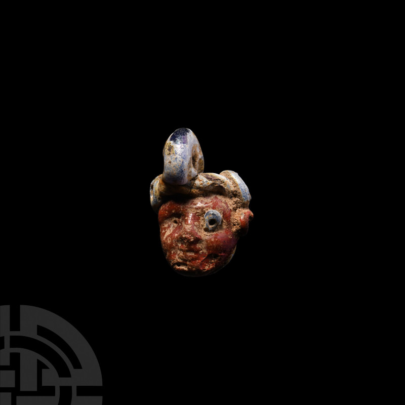 Phoenician Glass Face Pendant. 6th-3rd century B.C. A polychrome glass pendant f...