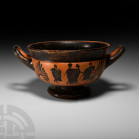 Greek Attic Black Figure Kylix. 5th century B.C. A substantial ceramic black ware kylix with carinated profile and flared rim, short stem above a broa...