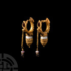 Large Eastern Hellenistic Gold Earrings with Garnets. 3rd-1st century B.C. A matched pair of substantial gold earrings, each composed of a gold cresce...