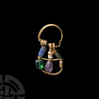Greek Gold Earring with Gemstones. 5th-3rd century B.C. A substantial gold earring composed of a D-shaped body with granulated collars and beads, piri...