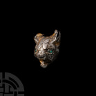 Scythian Gilt Silver Cat Head with Inlaid Eyes. 6th century B.C.-3rd century A.D. A sheet-silver animal head modelled in the half-round as a roaring f...