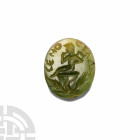 Greek Inscribed Gemstone with Seated Harpokrates. 1st century B.C. A green chalcedony gemstone engraved with young naked Harpokrates seated upon a mas...