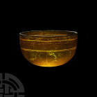 Hellenistic Amber Glass Bowl. 3rd-1st century B.C. An amber-coloured hemispherical glass bowl with circumferential rotary grinding marks on the interi...