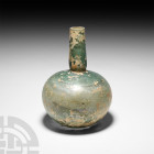 Large Roman Green Glass Bottle. 3rd-4th century A.D. A green glass bottle with globular body, balustered neck and ground rim; some iridescence remaini...