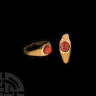 Roman Gold Ring with Amphora Gemstone. 3rd century A.D. A gold ring of irregular ellipsoid shape, with trapezium-shaped section, widening toward the c...