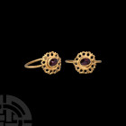 Roman Gold Ring with Garnet. 3rd-4th century A.D. An openwork bezel, central cell with inset keeled garnet cabochon, later gold hoop. 2.41 grams, 23.4...