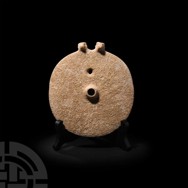 Twin-Headed Disc Idol. 3rd-2nd millennium BC. A carved limestone disc with trump...
