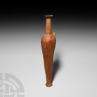 Hellenistic Terracotta Alabastron. 3rd-2nd century B.C. A tall ceramic alabastron composed of a slender tapering body, rounded shoulder, tapering cyli...