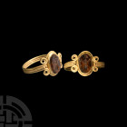 Greek Ant Gemstone in Gold Ring. 5th-4th century B.C. A cut and polished garnet intaglio engraved with a stylised ant; set into a later gold filigree ...
