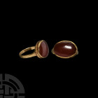 Hellenistic Gold Ring with Gemstone. 3rd-1st century B.C. A gold ring with D-section hoop supporting an oval bezel set with a polished carnelian caboc...