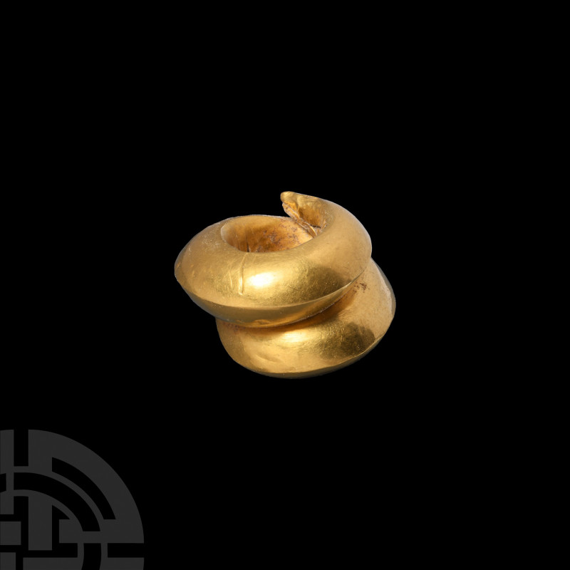 Achaemenid Gold Hair Ring. c.5th century B.C. A hollow-formed gold spiral hair o...