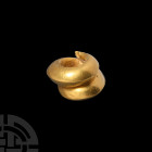 Achaemenid Gold Hair Ring. c.5th century B.C. A hollow-formed gold spiral hair ornament of carinated profile with tapering ends. 14.59 grams, 31 mm (1...
