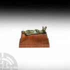 Early Italic Recumbent Lion Attachment. c.9th-7th century B.C. A tapered bronze pendant or attachment, with a recumbent lion seated at the narrow end,...