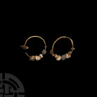 Greek Gold Hoop Earrings with Pearls. 5th-3rd century B.C. A matched pair of gold earrings, each composed of a round-section hoop, onto which are thre...