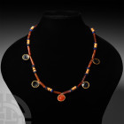 Elamite Necklace with Gold Cup Pendants. 2nd millennium B.C. A restrung necklace composed of carnelian, lapis lazuli and sheet-gold beads of spool, tu...