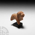 Greek Terracotta Dog Figure. 5th-3rd century B.C. A terracotta figure modelled in the round as a dog with stylised features, standing on four rounded ...