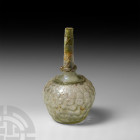 Honeycomb Vessel. 9th-10th century A.D. A green glass bottle with squat piriform body and tapering cylindrical neck, applied trail to the neck base, h...
