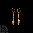 Hellenistic Gold Earrings with Carnelian Bead Drops. 3rd-2nd century B.C. A pair of gold earrings, each composed of an oval hoop, openwork chain and '...