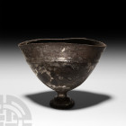 Hellenistic Silver Chalice. 3rd-1st century A.D. A silver chalice with hemispherical bowl and ogival foot, raised circumferential band to the upper bo...