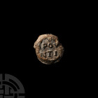 Roman Lead Seal with Robed Figure. 1st-4th century A.D. A bifacial coin-shaped lead seal: obverse with raised Latin text: '[ ]POV[ ] / [ ]NTI[ ]'; rev...