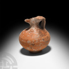 Roman Terracotta Juglet. 1st-2nd century A.D. A terracotta juglet with carinated body, broad shoulder, trefoil mouth, ribbed strap handle and shallow ...