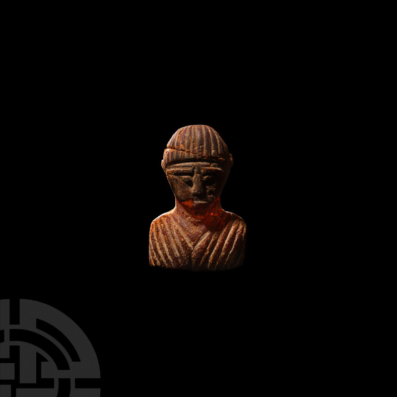 Western Asiatic Baltic Amber Bust Pendant. 9th-12th century A.D. A pendant carve...