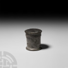Roman Lead Pyxis with Lid. c.1st-2nd century A.D. A cylindrical lead pyxis with stepped foot and lid, decorative concentric grooves and zigzag motif. ...