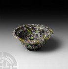 Roman Millefiori Glass Patella Cup. 1st century A.D. or later. A millefiori glass cup with double ogee bowl and basal ring, the black glass field with...