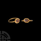 Roman Clasped Hands Gemstone in Gold Ring. 2nd-3rd century A.D. A gold ring with circular hoop, oval-shaped bezel with pearled edge, set with a carnel...