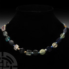 Roman Glass Bead Necklace. 2nd-4th century A.D. A restrung designer necklace composed of round tabular and other bead types in blue and clear glass; i...