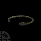 Roman Snake-Headed Bracelet. 1st-4th century A.D. A bronze penannular bracelet with slender body and flattened terminals with stylised snake head deta...