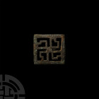 Roman Swastika Plate Brooch. 2nd-3rd century A.D. A plate brooch composed of a square body framing an openwork swastika motif; pin and catchplate to r...