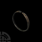 Roman Animal-Headed Bracelet. 1st-3rd century A.D. A bronze penannular bracelet comprising a D-section hoop, flat-section, deltoid-shaped terminals fo...