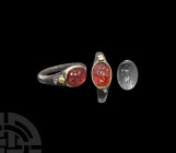 Eastern Roman Silver and Gold Ring with Victory Gemstone. 2nd-3rd century A.D. A silver ring with tapering D-section hoop and gold oval-shaped bezel, ...