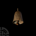 Roman Bell with Clapper. 1st-3rd century A.D. A bell with tapering oval-section body and pierced rectangular lug, clapper intact. 105 grams, 81 mm hig...
