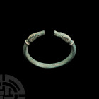 Roman Animal-Headed Bracelet. 2nd-4th century A.D. A bronze penannular bracelet with lozenge-section hoop and collared terminals formed as stylised do...