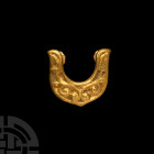Viking Age Gold Horseshoe-Shaped Belt Mount. 8th-9th century A.D. A gold Avar belt hole-guard, of semi-circular form with projecting lobe, the surface...