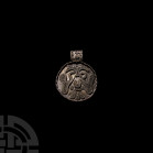 Viking Age Silver Filigree Pendant with Conjoined Ravens. 9th-11th century A.D. A silver discoid pendant, the upper face decorated with a two-headed f...