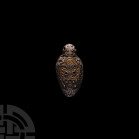 Viking Silver Pendant with Odin. 10th-12th century A.D. A domed silver pendant, ovoid in plan with applied granulation and filigree in the form of a s...
