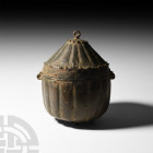 Medieval Ribbed Lidded Vessel. 12th century A.D. or later. A ribbed bronze vessel on four short feet with a domed lid consisting of ribbed lappets, su...
