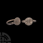 Byzantine Silver Merchant's Ring. 6th-8th century A.D. A silver ring with D-section hoop and discoid bezel bearing a monogram within a beaded border. ...