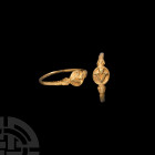 Gold 'Love You' Posy Ring. 17th-18th century A.D. A gold ring with slender D-section hoop, arms with collars and stylised lotus heads, oval bezel with...