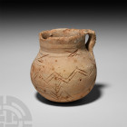 Syrian Incised Jug. 2nd-1st millennium B.C. A ceramic jug composed of a bulbous body, broad neck and integral strap handle decorated with incised cros...