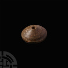 Persian Spindle Whorl. Iron Age II, 11th-6th century B.C. A conical limestone spindle whorl with flat base and incised circumferential groove to the u...