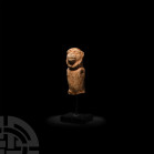 Bactrian Children's Toy Figure. c.22nd-17th century B.C. A white stone figure modelled in the round as a monkey, with semi-naturalistic detailing to t...