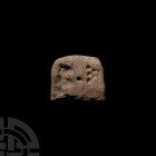 Mesopotamian Proto-Cuneiform Tablet Half. 4th millennium B.C. A cut half of a D-shaped ceramic proto-cuneiform tablet with impressed forms to both fac...