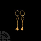 Sassanian Gold Earrings with Flower Drops. 3rd-7th century A.D. A pair of gold earrings, each comprising intertwined hoops, an openwork chain and thre...