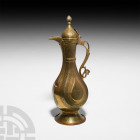 Bukhara Brass Ewer. c.1800 A.D. A brass ewer with pear-shaped body, hinged domed lid and incised arabesque medallions and scrolling floral bands. 765 ...